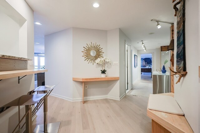 hall with track lighting and light hardwood / wood-style floors