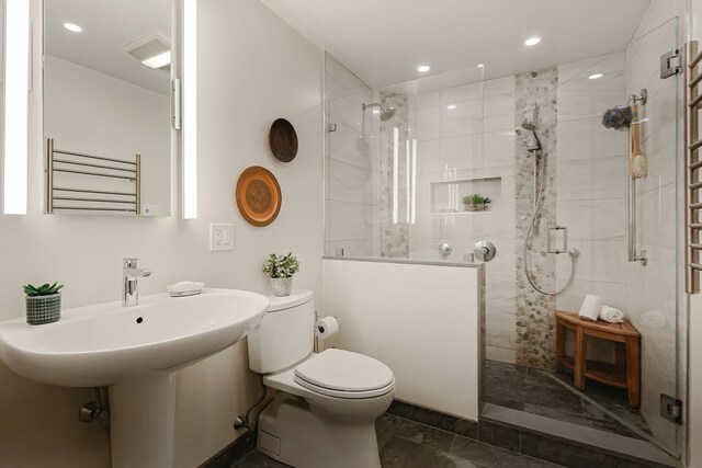 bathroom with radiator heating unit, tiled shower, and toilet