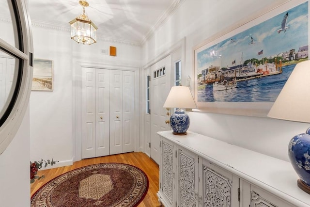 11 Forest Ln Unit 11, Scituate, MA 02066 - foyer featuring light wood-style floors, ornamental molding, and a chandelier