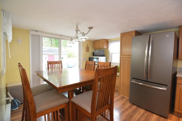 dining room with light wood-style floors and a chandelier