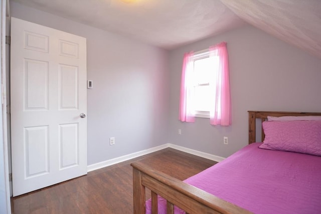 bedroom featuring dark wood-style floors, vaulted ceiling, and baseboards