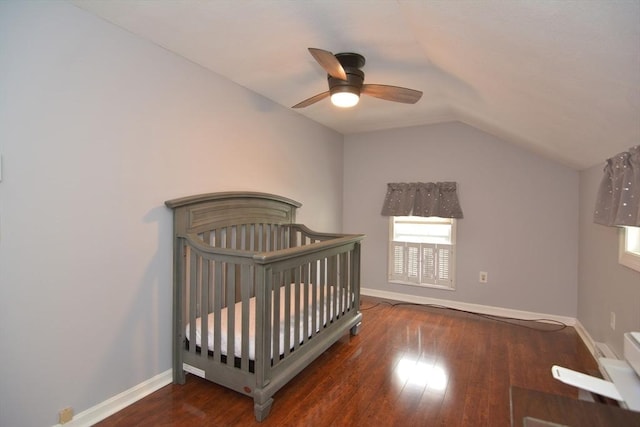 bedroom featuring lofted ceiling, hardwood / wood-style floors, baseboards, ceiling fan, and a nursery area