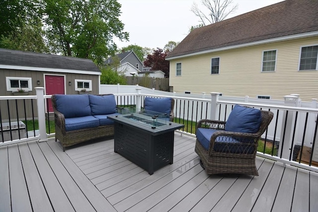 wooden terrace featuring an outdoor living space, an outdoor structure, and fence