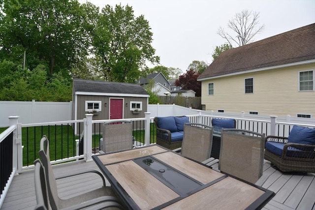 wooden deck featuring outdoor dining space, an outdoor structure, and a storage unit