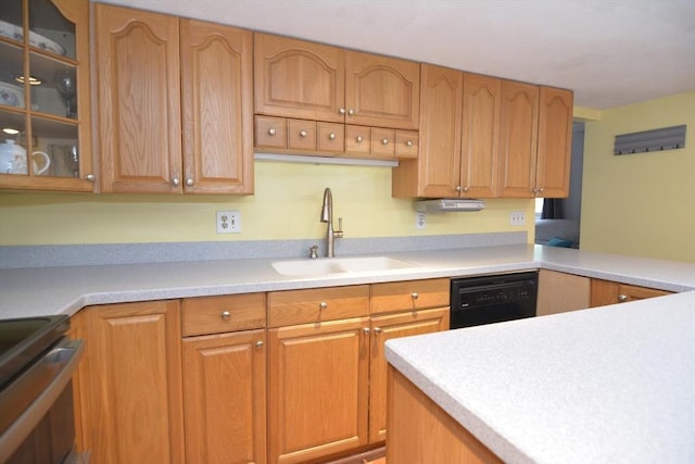 kitchen featuring a sink, black dishwasher, light countertops, and glass insert cabinets