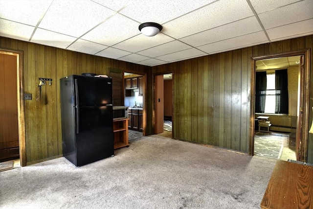 405 Warren St, Fall River, MA 02721 - kitchen featuring freestanding refrigerator, stainless steel microwave, wooden walls, a paneled ceiling, and light carpet