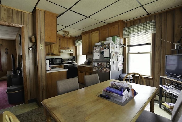 405 Warren St, Fall River, MA 02721 - kitchen with black appliances, wood walls, under cabinet range hood, healthy amount of natural light, and light countertops