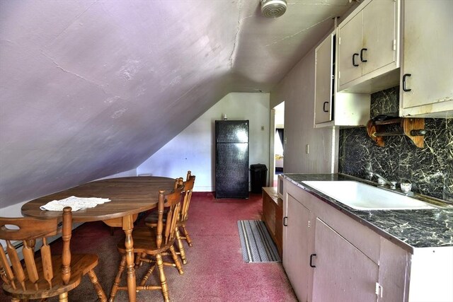 405 Warren St, Fall River, MA 02721 - kitchen featuring vaulted ceiling, a sink, backsplash, dark carpet, and dark countertops