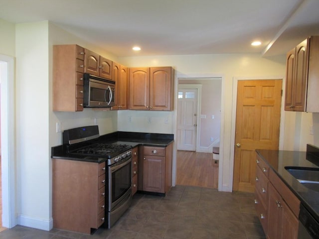 49 Vassall St, Quincy, MA 02170 - kitchen featuring appliances with stainless steel finishes, dark countertops, dark tile patterned flooring, recessed lighting, and brown cabinetry
