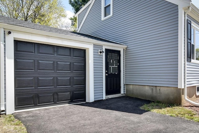 8 Lee Rd, Sharon, MA 02067 - view of exterior entry with aphalt driveway, a shingled roof, and a garage