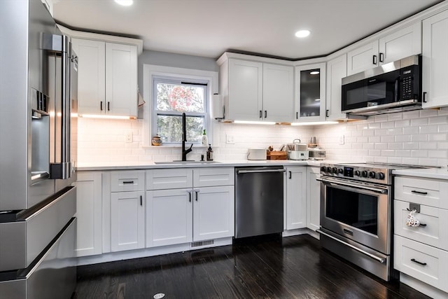 8 Lee Rd, Sharon, MA 02067 - kitchen with white cabinets, a sink, appliances with stainless steel finishes, light countertops, and dark wood-style flooring