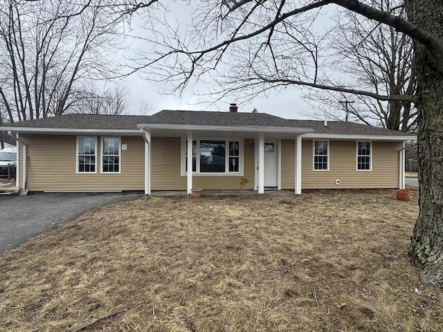 ranch-style house with driveway and a chimney