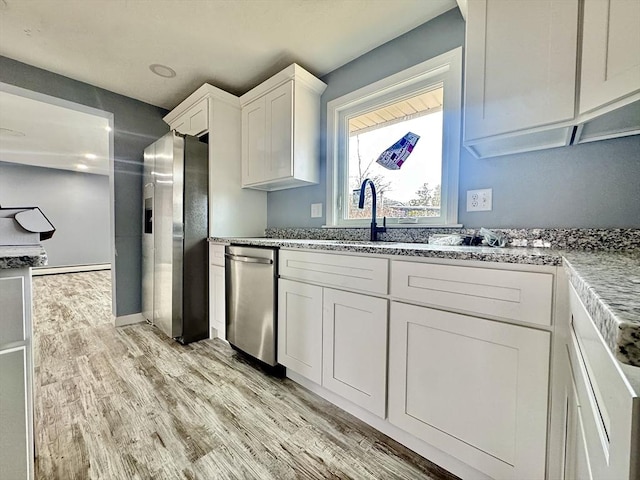 kitchen featuring light stone counters, light wood-style floors, white cabinetry, and stainless steel fridge with ice dispenser