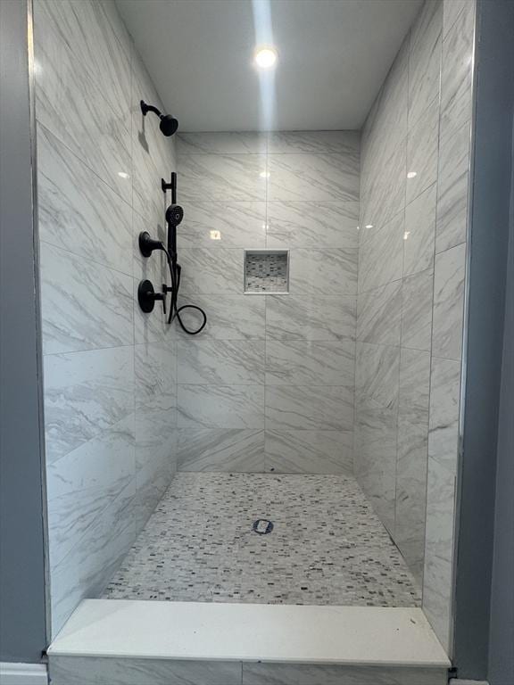 full bath with a tile shower