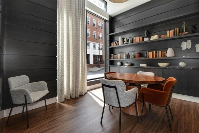 interior space featuring built in shelves, wood walls, and dark hardwood / wood-style floors