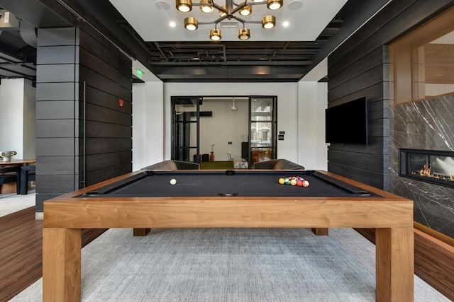 playroom with wood-type flooring, a premium fireplace, and billiards