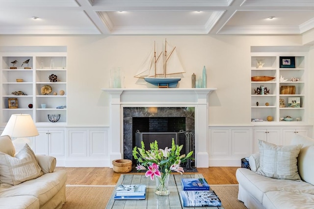 living room with a high end fireplace, coffered ceiling, beam ceiling, and light hardwood / wood-style flooring