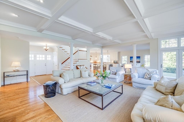 living room featuring an inviting chandelier, coffered ceiling, light hardwood / wood-style floors, and ornate columns