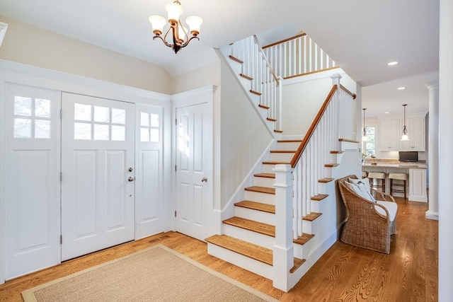 foyer entrance with a notable chandelier and light hardwood / wood-style floors