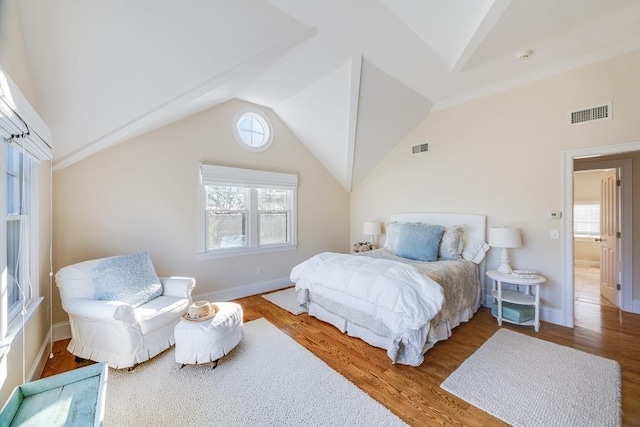 bedroom with wood-type flooring and vaulted ceiling