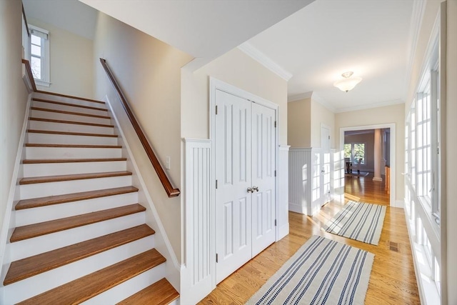 stairs featuring crown molding and wood-type flooring