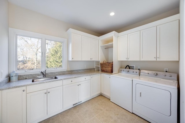 laundry room featuring cabinets, washing machine and dryer, sink, and light tile patterned floors