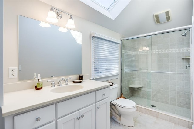 bathroom with a skylight, vanity, walk in shower, toilet, and tile patterned floors