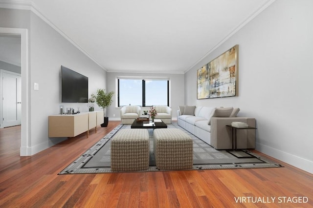 living area with baseboards, ornamental molding, and wood finished floors