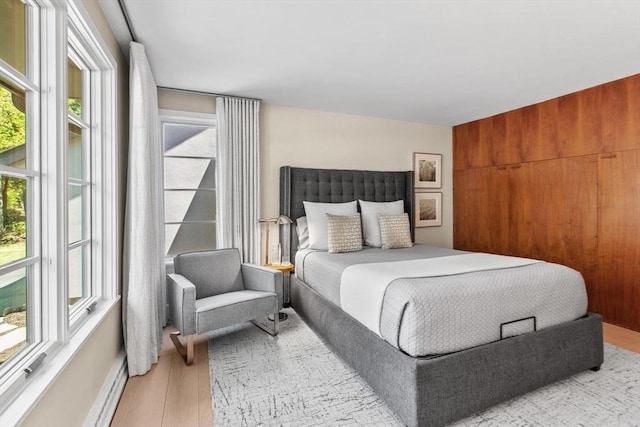 bedroom featuring multiple windows, wood finished floors, and baseboard heating