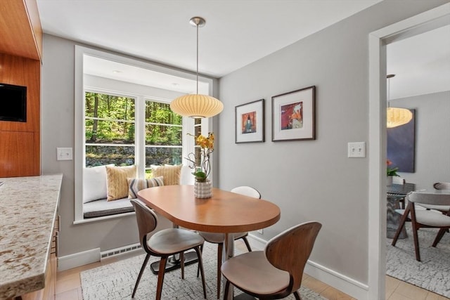 dining area with baseboards and light wood finished floors