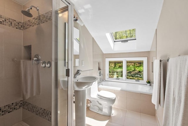 full bathroom featuring a skylight, a shower stall, tile patterned floors, a bath, and toilet