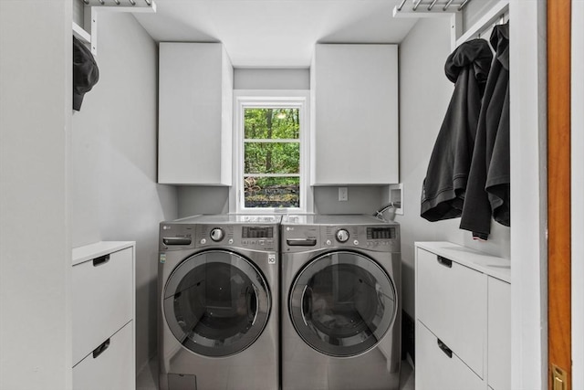 washroom featuring washer and dryer and cabinet space