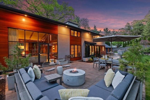 view of patio with an outdoor living space with a fire pit and outdoor dining area