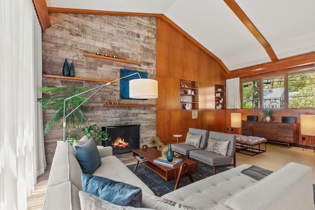 living room featuring lofted ceiling, wooden walls, built in features, a stone fireplace, and wood finished floors