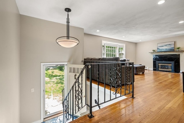 living room featuring wood finished floors, recessed lighting, and a tiled fireplace