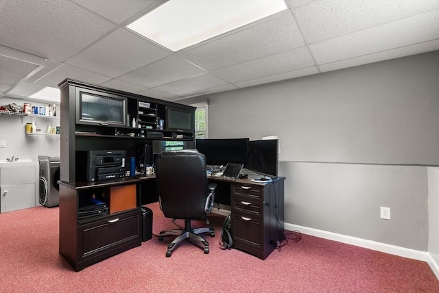 carpeted office with washing machine and clothes dryer, a paneled ceiling, baseboards, and a sink