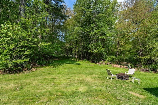 view of green lawn with a fire pit