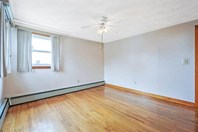 spare room with a baseboard heating unit, wood finished floors, and ceiling fan