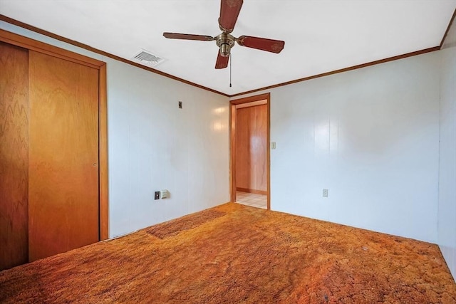 unfurnished bedroom with crown molding, carpet, visible vents, and ceiling fan