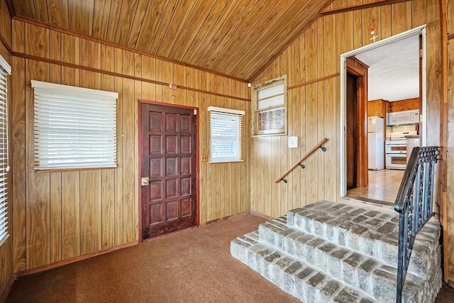 bedroom with freestanding refrigerator, carpet floors, wooden walls, wooden ceiling, and lofted ceiling