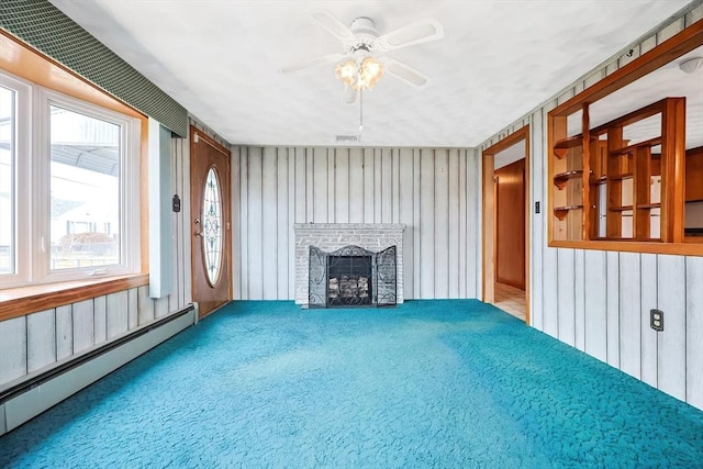 interior space with visible vents, a fireplace, ceiling fan, and a baseboard radiator