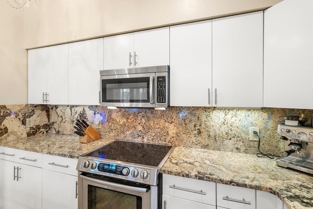 341 Beacon Unit 2F, Boston, MA 02116 - kitchen featuring appliances with stainless steel finishes, white cabinetry, decorative backsplash, and light stone counters
