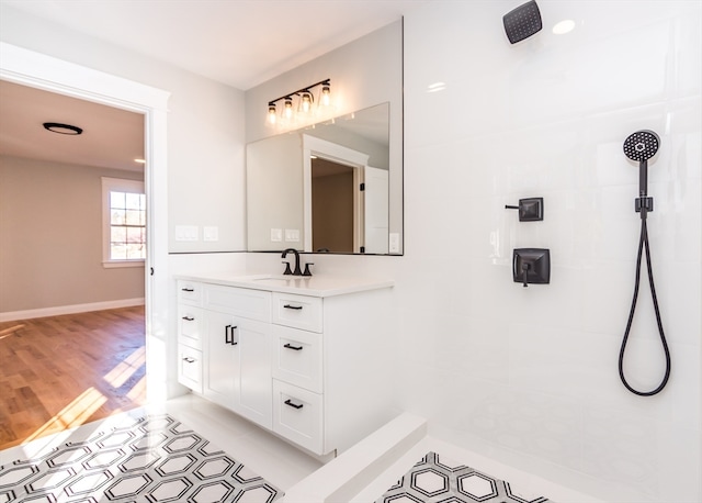 bathroom with a tile shower, hardwood / wood-style floors, and vanity