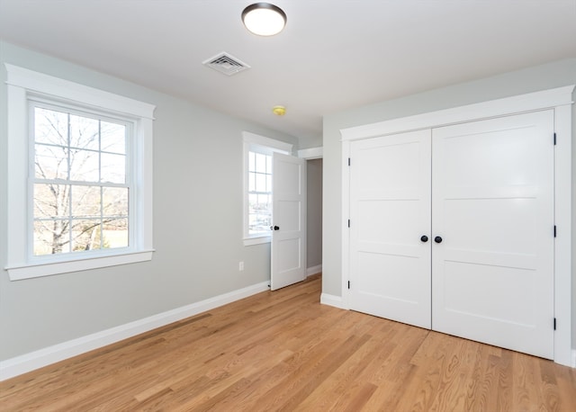 unfurnished bedroom featuring light hardwood / wood-style flooring and a closet