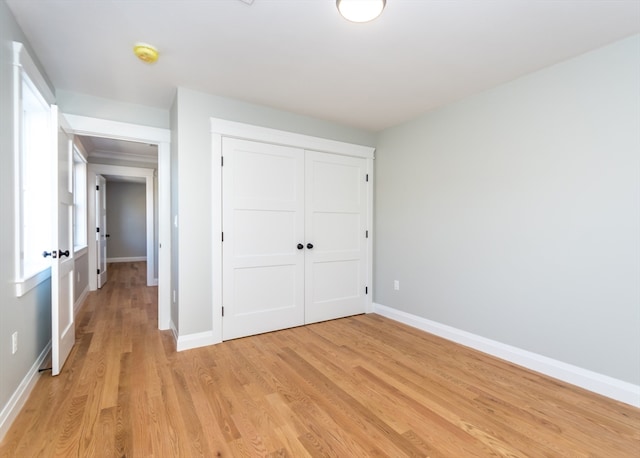 unfurnished bedroom featuring light hardwood / wood-style flooring and a closet