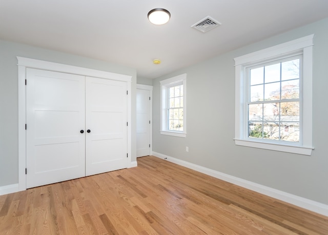 unfurnished bedroom featuring a closet and light hardwood / wood-style floors