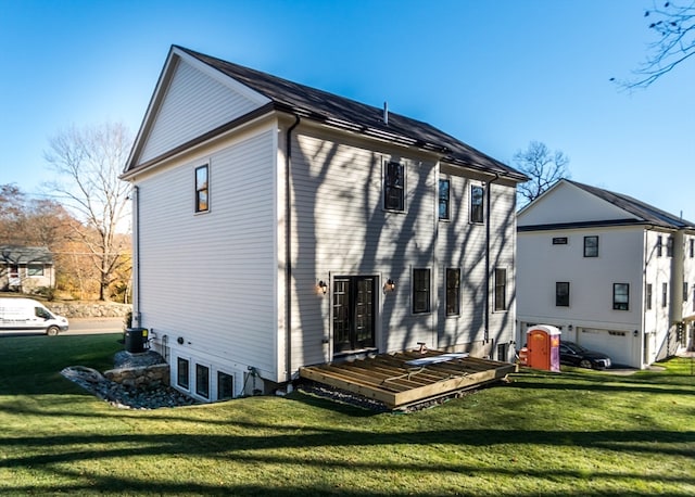 back of property featuring a lawn and a garage