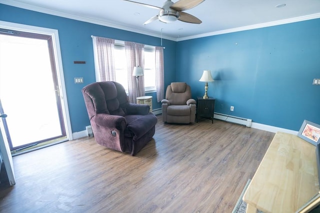 living area with crown molding, wood-type flooring, ceiling fan, and a baseboard heating unit