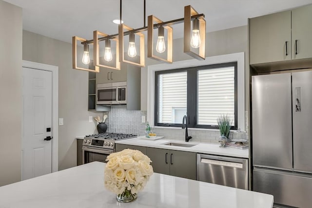 kitchen featuring sink, stainless steel appliances, decorative backsplash, and decorative light fixtures