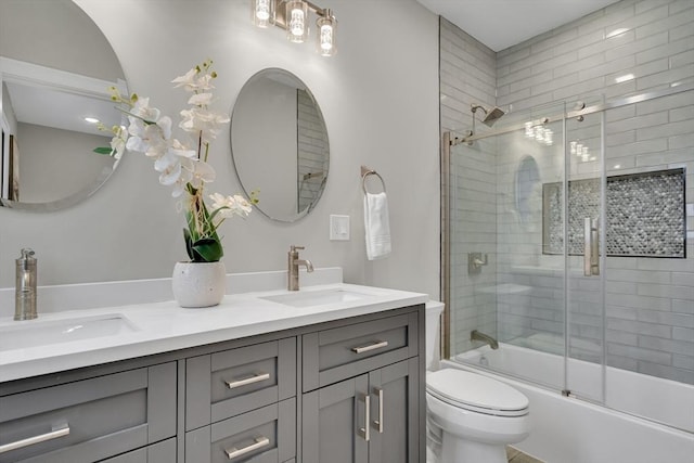 full bathroom featuring combined bath / shower with glass door, vanity, and toilet